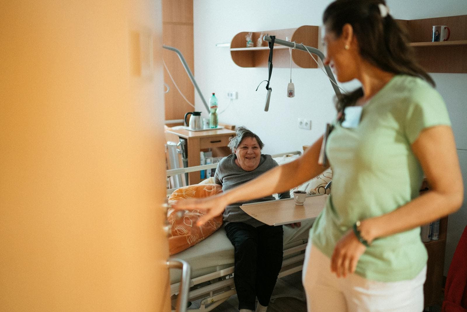 A caregiver interacts warmly with an elderly resident — daytime shift in 24-hour home care.