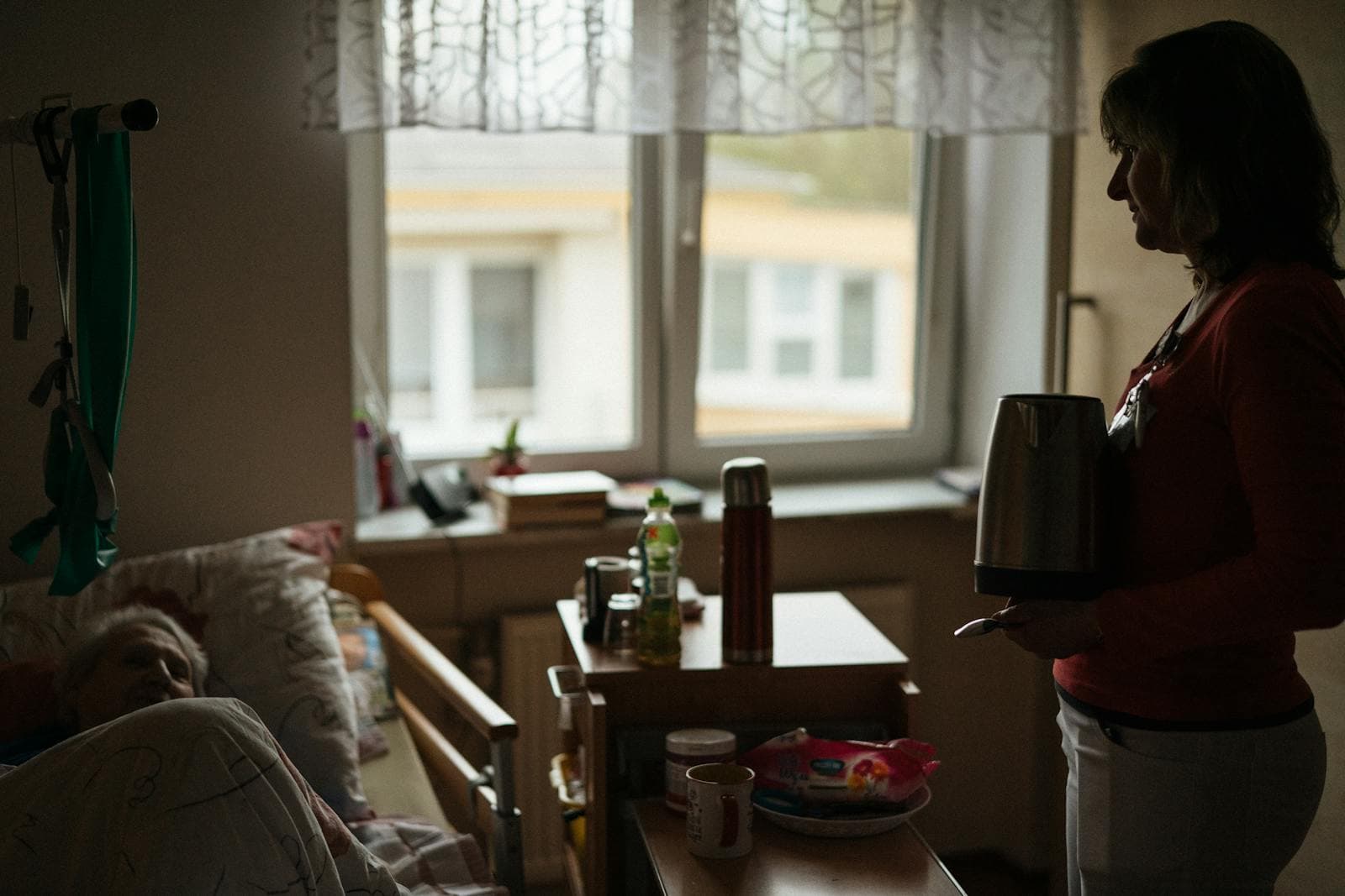 A caregiver prepares a warm drink for a senior — a quiet moment in continuous home care.